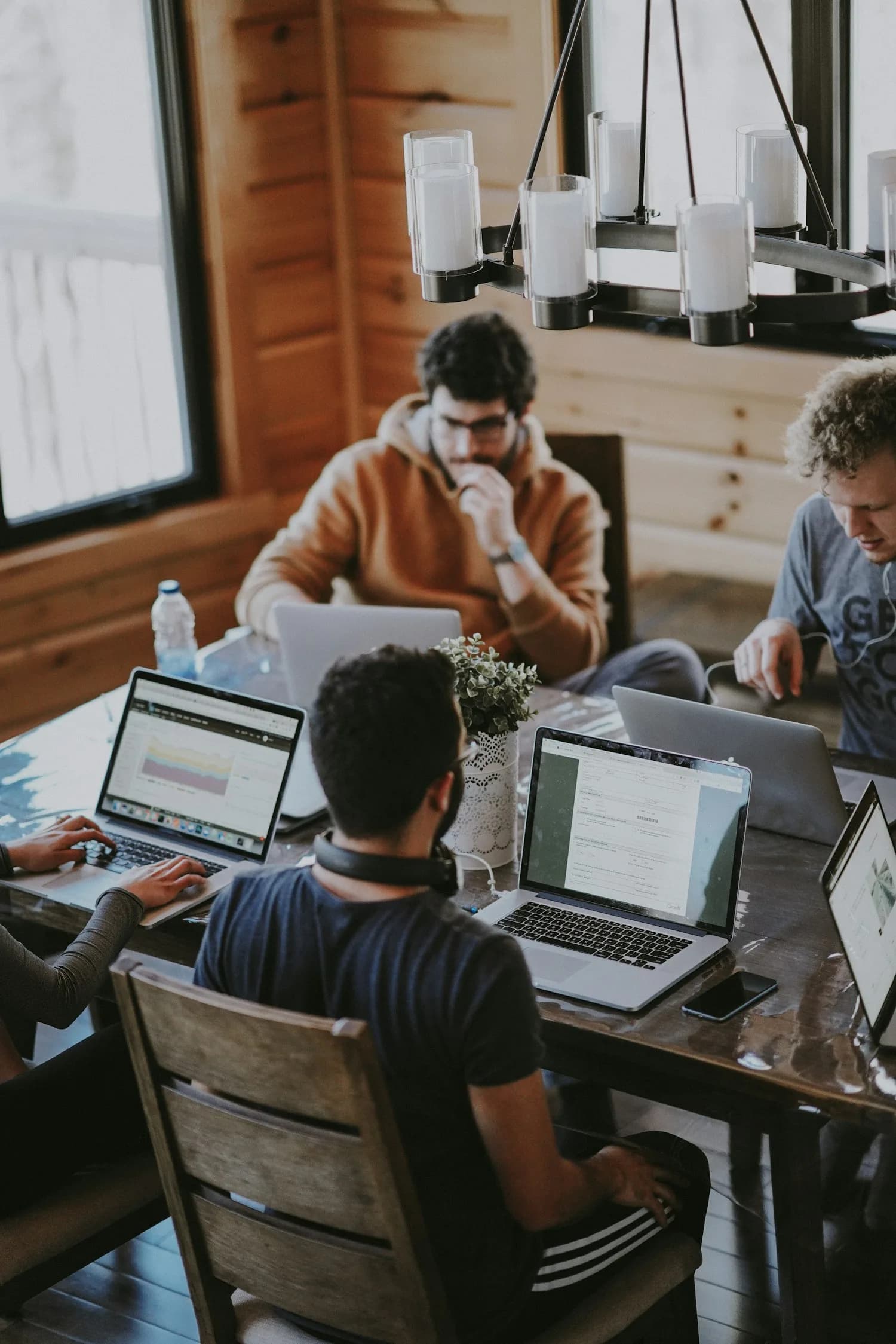 People collaborating around laptops at a table; illustrative stock photograph